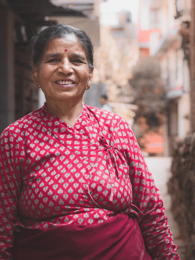 A smiling woman in a red patterned kurta