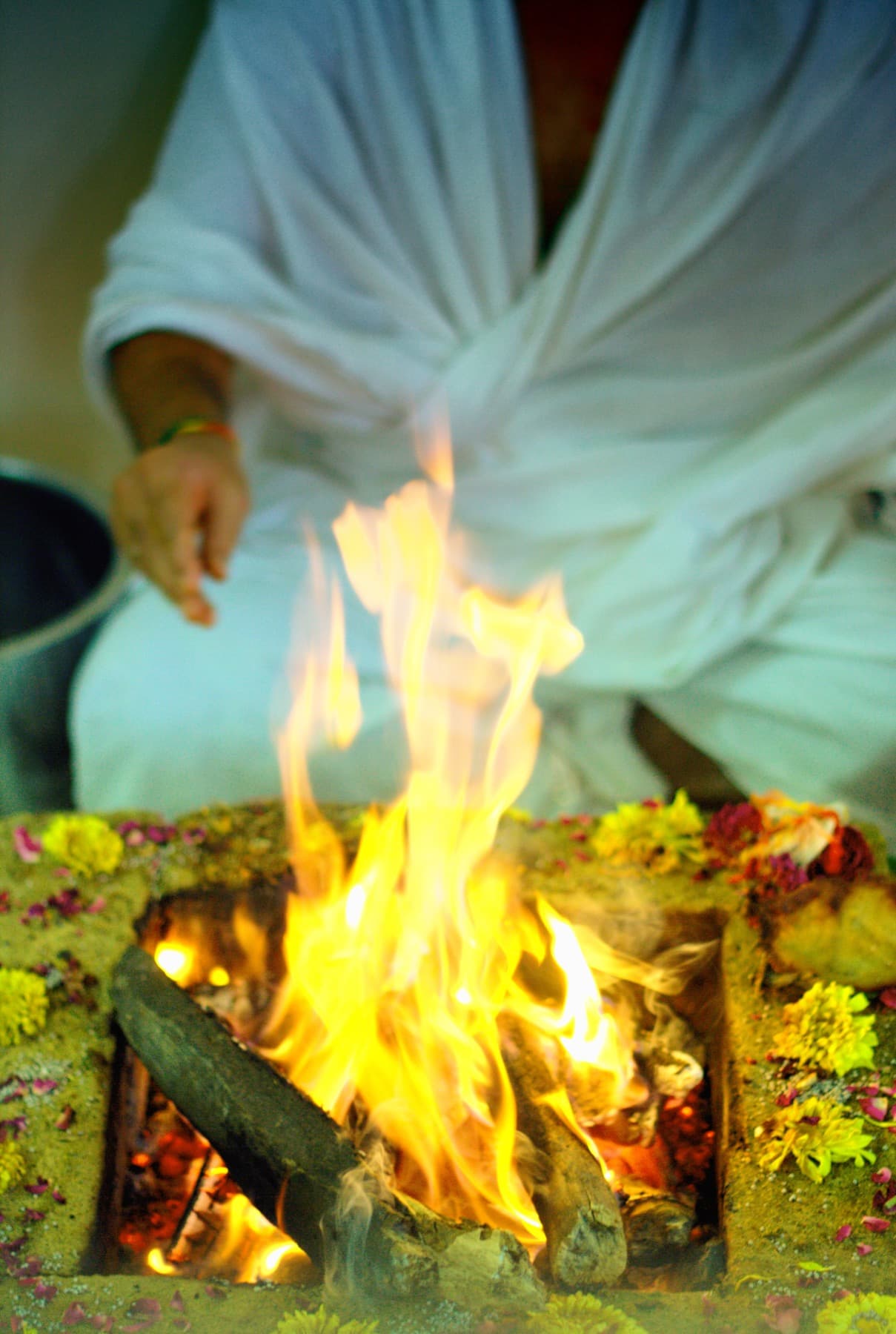 Flames rising from a flower-ringed havan kuṇḍ during a yajña
