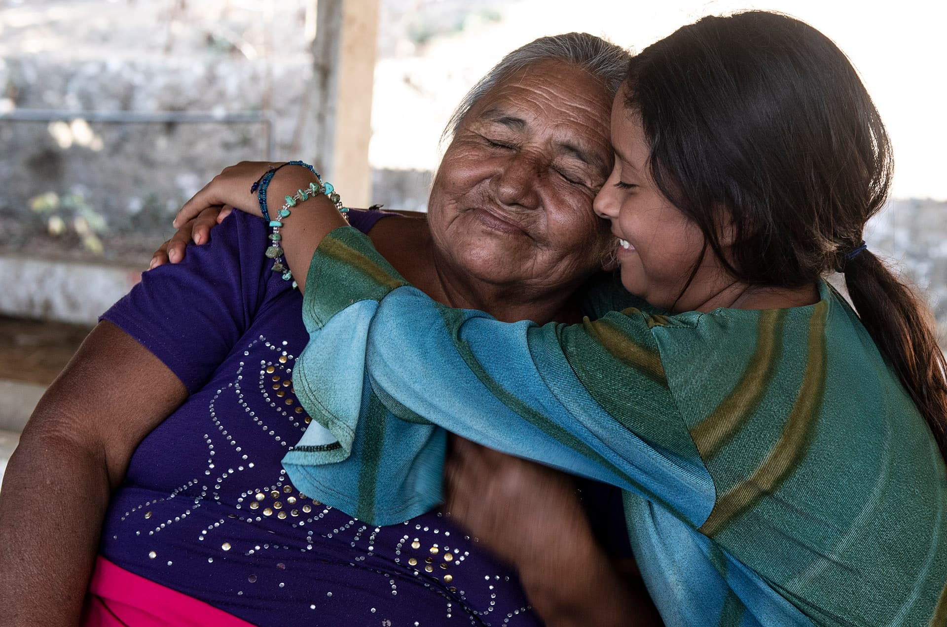 A grandmother embracing her granddaughter in Mexico